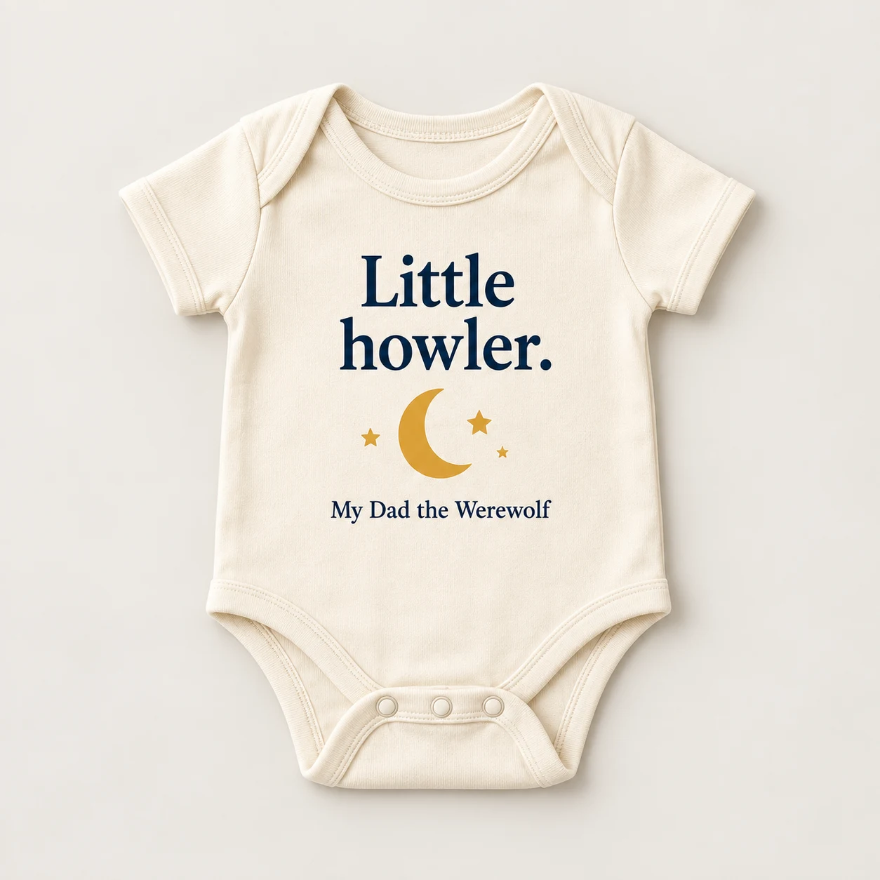 Concept mockup of a cream baby bodysuit reading Little howler. with a gold crescent moon.